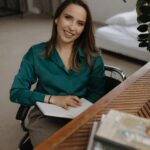 Confident woman sitting at a desk in modern office interior.